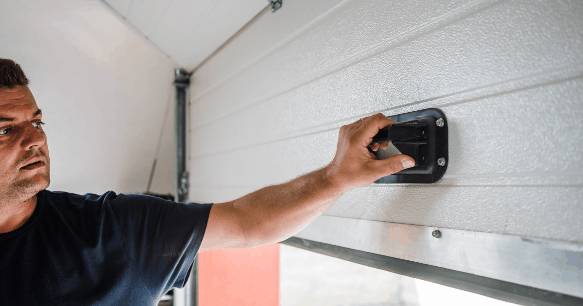 man inspecting bottom of garage door